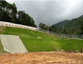 A green hill with a fence and a hill

AI-generated content may be incorrect.